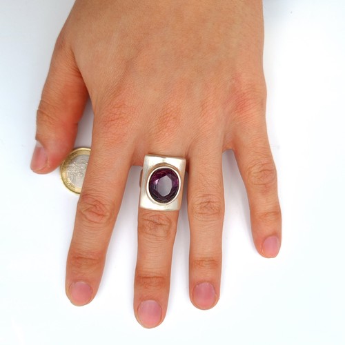 634 - A striking heavy gauge,  sterling silver ring, set with a bright natural facet cut Amethyst. Ring si... 