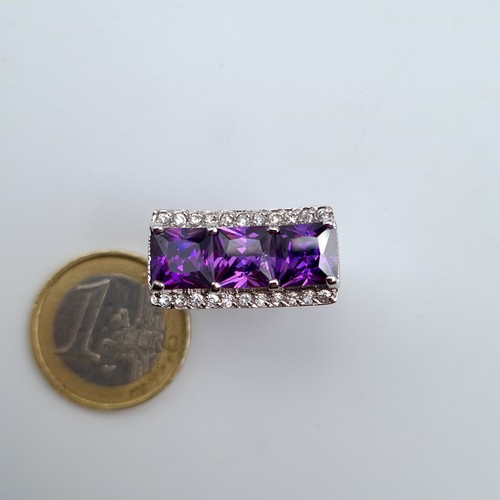 630 - A three stone Amethyst sterling silver cocktail ring, set with an unusual curved gem stone mount. Ma... 