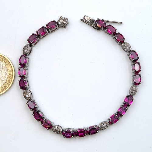 625 - Star Lot : A fine example of a Rhodolite and Diamond sterling silver tennis bracelet, of 11.9 grams.... 