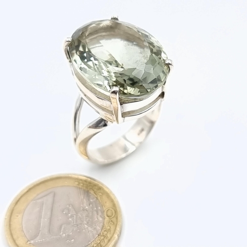 181 - A generously large Green Amethyst ring, featuring a bright facet cut central stone and set in sterli... 