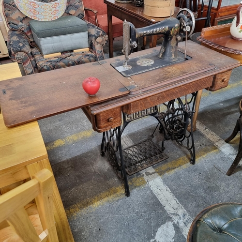 904 - A gorgeous example of an antique Singer treadle sewing machine. With a cast iron base and fly wheel,... 