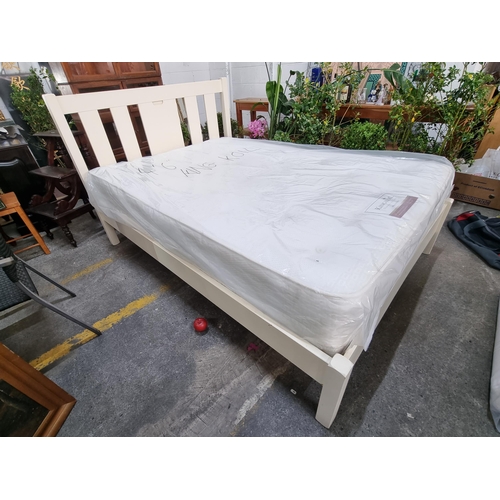 922 - A large double bed frame and brand new mattress. The frame has a nice slat back headboard in a cream... 