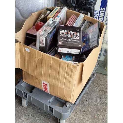 937 - A large box containing an impressive collection of DVDs and CDs including a Clint Eastwood film box ... 