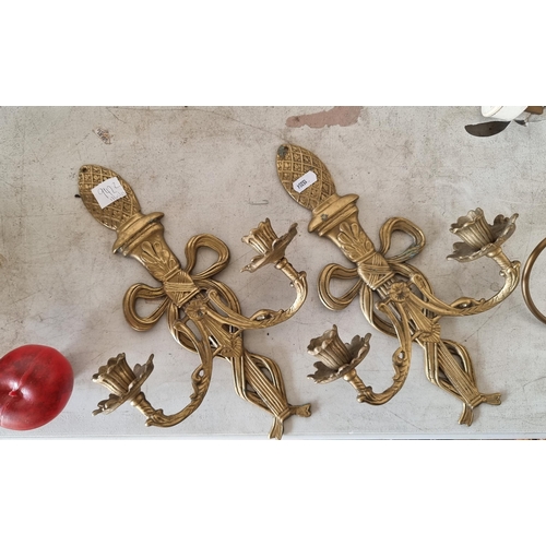 942 - Two vintage brass wall mounting candle sconces with two branches each. Decorated in a scroll and fol... 