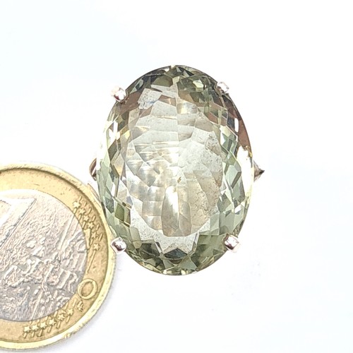 181 - A generously large Green Amethyst ring, featuring a bright facet cut central stone and set in sterli... 