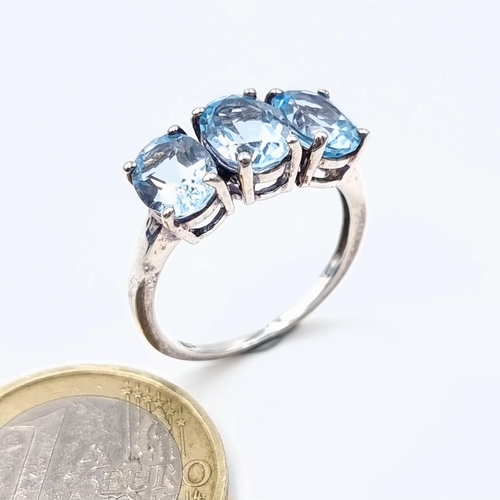 38 - A show stopping sterling silver three stone blue gem stone ring. Ring size: P. Weight: 3.29 grams.