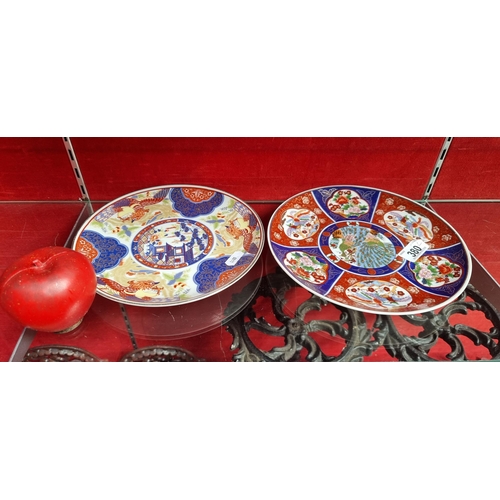 380 - Two ornate ceramic plates in the Japanese Imari style. Both featuring colourful bird and foliate mot... 