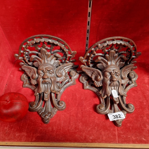 382 - A pair of heavy cast metal wall plant sconces boasting pierced detail and masks to front.