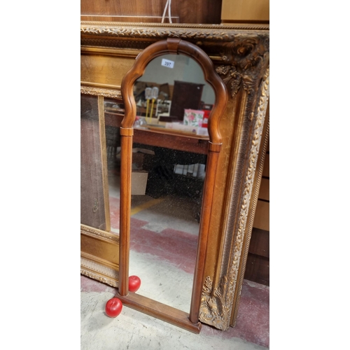 397 - A charming large wall mirror housed in a carved wooden frame with scroll detailing to top. H107cm