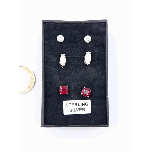 556 - A collection of three pretty sterling silver stud earrings, featuring Red gem stones, Fire Opals and... 