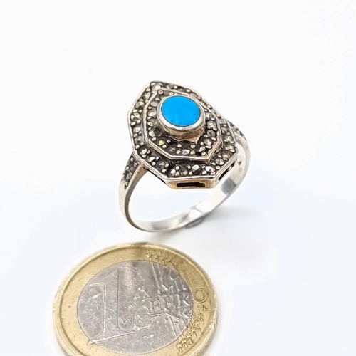 592 - A very pretty vintage sterling silver ring, set with an intricate centre stone and a channel cut gra... 