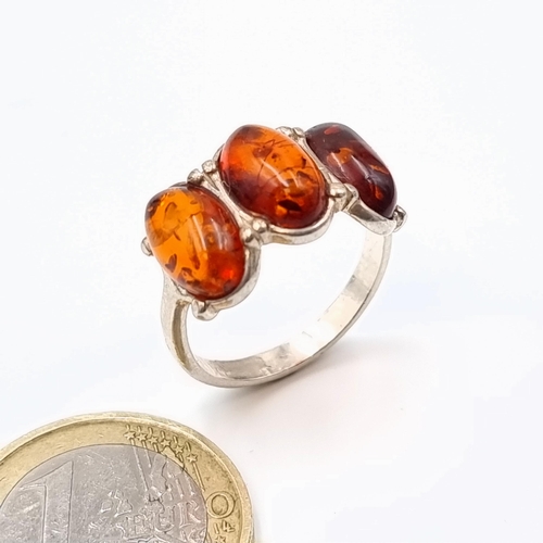 593 - A striking three stone Baltic Amber sterling silver ring. Ring size: R. Weight: 3.28 grams. Fabulous... 