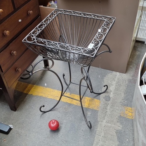 637 - A large wrought metal plant stand with lovely scroll ornament to legs and top.