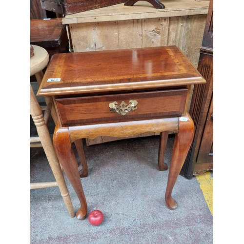 662 - A lovely golden mahogany side table with single drawer to front boasting brass drop handle. Held on ... 