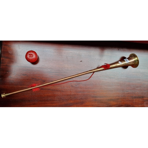 669 - A decorative long  brass and copper hunting horn with red cord for hanging.