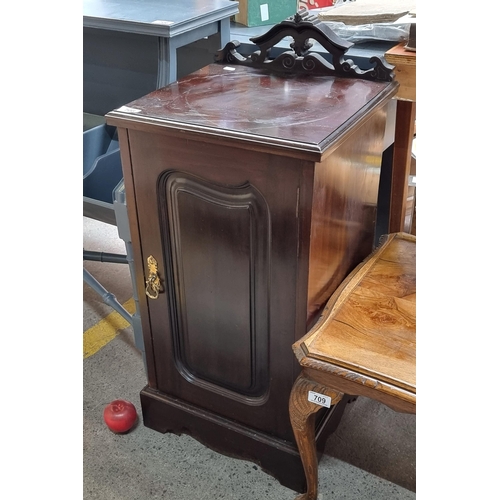 708 - A wooden bedside table with a nice pierced pedimental gallery back. Door to front opens to reveal on... 