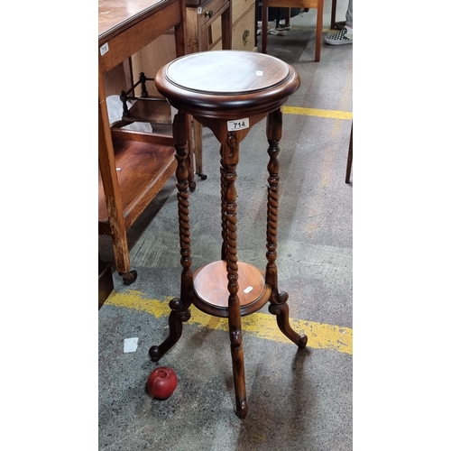 714 - A charming floor standing plant stand with single tier to base, held on attractive barely twist supp... 