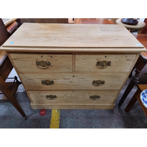 719 - A solid antique  pine chest of drawers with four drawers boasting brass drop handles. Deep drawers f... 