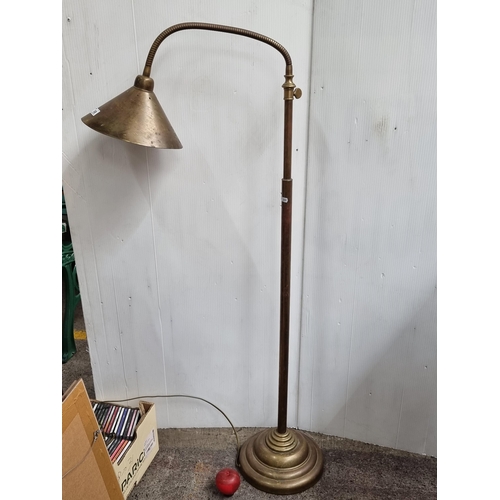 749 - A handsome example of a floor standing lamp with an articulated stem and conical shade. A heavy qual... 