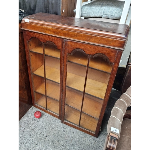 750 - A charming Edwardian cabinet with four full length shelves behind glass doors. This example features... 