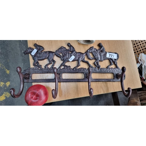 777 - A heavy cast metal wall mounting coat rack with four hooks, showing three race horses to top. In a r... 