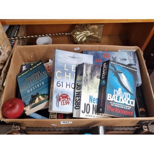 957 - A box filled with novels including works by authors Lee Child, Jo Nesbo and David Baldacci.