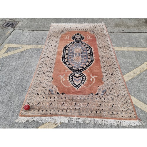 776 - Star Lot : A large hand made woolen rug in shades of terracotta, sky blue and sand. Made by Fazal El... 