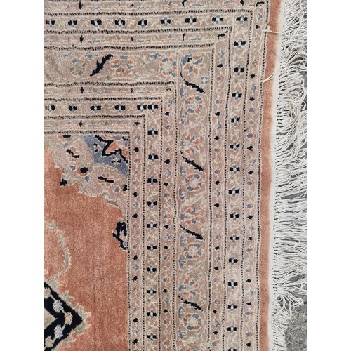 776 - Star Lot : A large hand made woolen rug in shades of terracotta, sky blue and sand. Made by Fazal El... 