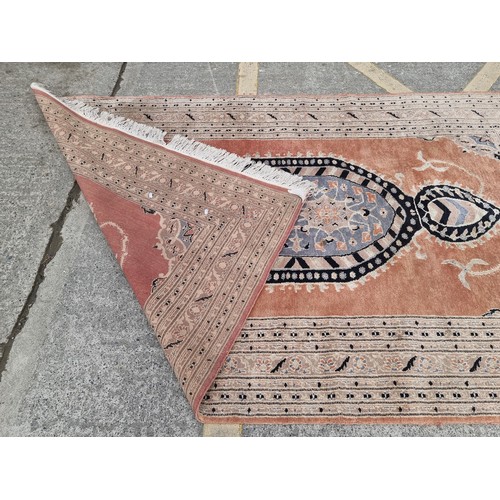 776 - Star Lot : A large hand made woolen rug in shades of terracotta, sky blue and sand. Made by Fazal El... 