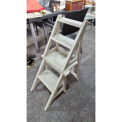 775 - A solid wooden slat back chair that folds out to become a step ladder with four steps. In a rustic w... 