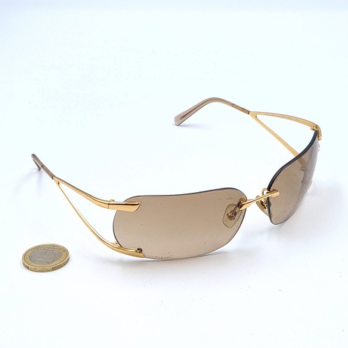 16 - A genuine pair of  Versace sunglasses, set with beige lenses and stylish gold metal frames which fea... 