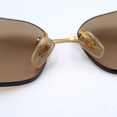 16 - A genuine pair of  Versace sunglasses, set with beige lenses and stylish gold metal frames which fea... 