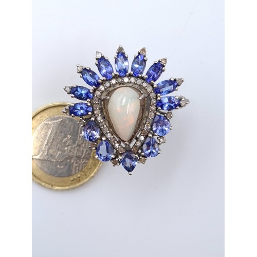 567 - Star Lot: An exceptionally crafted Diamond, Fire Opel and Tanzanite ring, featuring a central Fire O... 