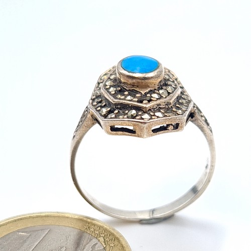 592 - A very pretty vintage sterling silver ring, set with an intricate centre stone and a channel cut gra... 