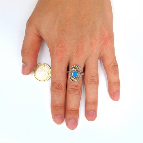 592 - A very pretty vintage sterling silver ring, set with an intricate centre stone and a channel cut gra... 