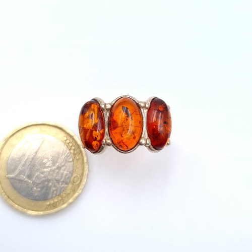 593 - A striking three stone Baltic Amber sterling silver ring. Ring size: R. Weight: 3.28 grams. Fabulous... 