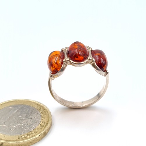 593 - A striking three stone Baltic Amber sterling silver ring. Ring size: R. Weight: 3.28 grams. Fabulous... 