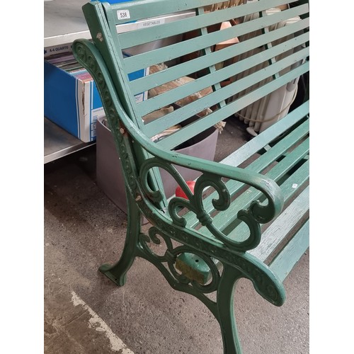 538 - A fabulous outdoor garden bench with heavy cast metal frame and slatted wooden seat, in a green fini... 