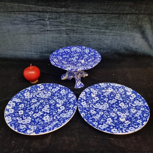 137 - Three matching blue and white floral ceramic items including a footed serving dish and two plates.