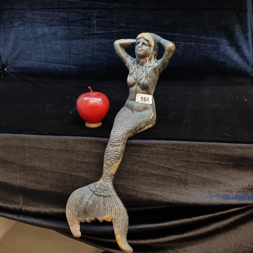 164 - A heavy cast metal tabletop mermaid figure. Designed to perch on the edge of a shelf or table with a... 