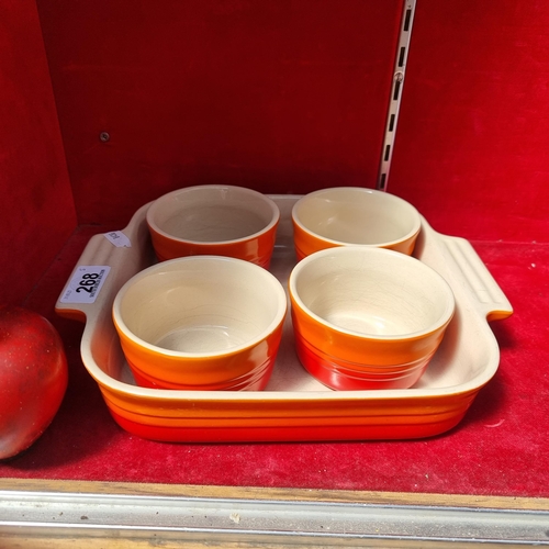 268 - Four fabulous pieces of Le Creuset stoneware including a large baking dish and four neatly sized ram... 