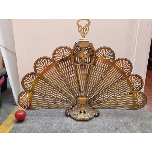 277 - A fabulous polished brass vintage fire screen in a peacock fan form with pierced grate and highly or... 