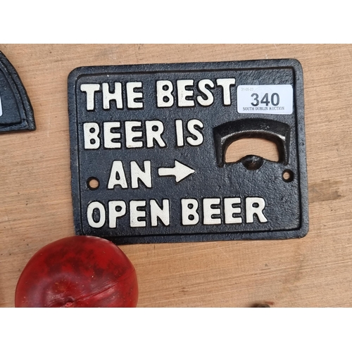 340 - A cast metal wall plaque with a bottle opener reading 