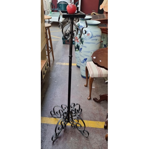 386 - A very heavy and tall wrought iron plant stand with curvilinear scroll ornament to top and base.