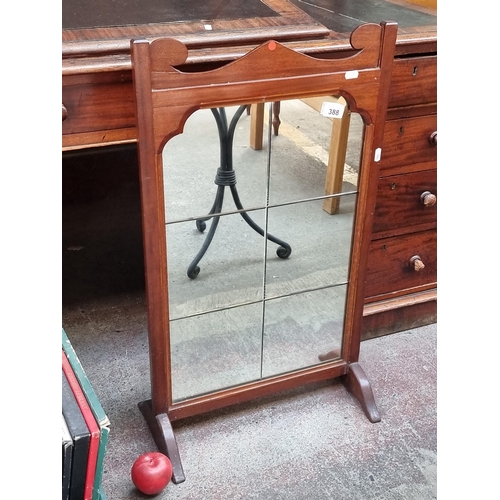 388 - A vintage fire screen with carved wooden frame and six mirrored panels to centre.