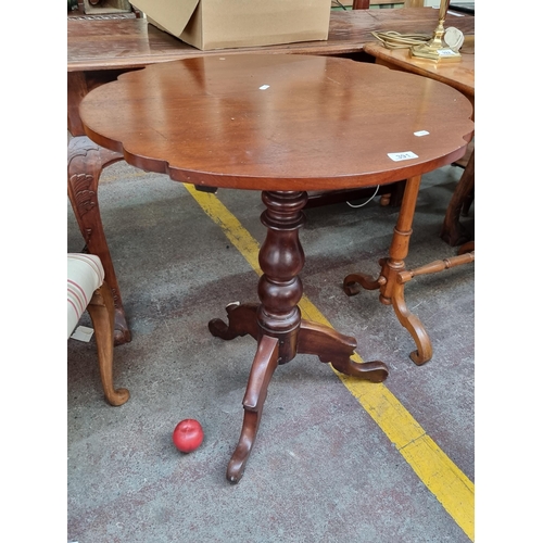 391 - A round antique serpentine edge side table held on a turned wood pilar base with cabriole tripod leg... 