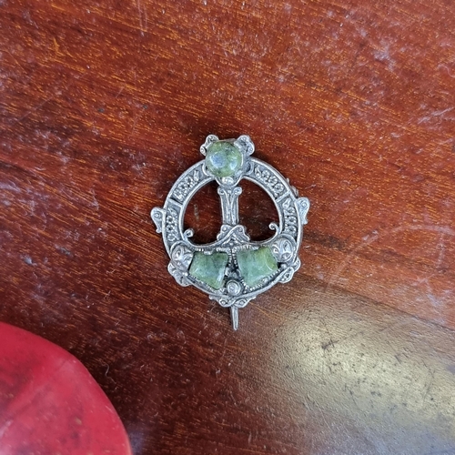 409 - An Irish silver Celtic revival Tara brooch, featuring a Connemara stone detailing. Pin needs attenti... 