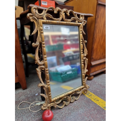 424 - An ornate antique wall mirror in a Baroque style. Housed in a lavish carved wood and moulded frame w... 