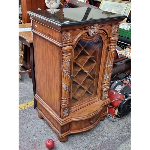 433 - Star Lot - An ornate wine cabinet to store ten bottles. Sporting billy goat mask detail flanked by r... 