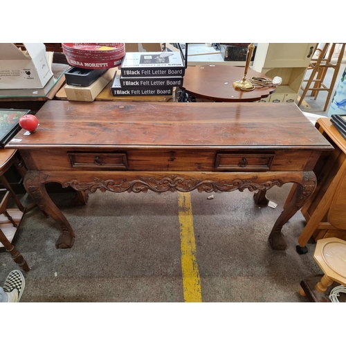 447 - Star lot : A profusely carved console table with impressive claw and ball feet and an ornate relief ... 